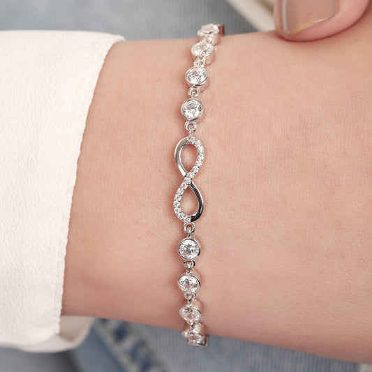 Woman wearing a 925 Sterling Silver bracelet with a sparkling infinity symbol and round stones. – Zavya